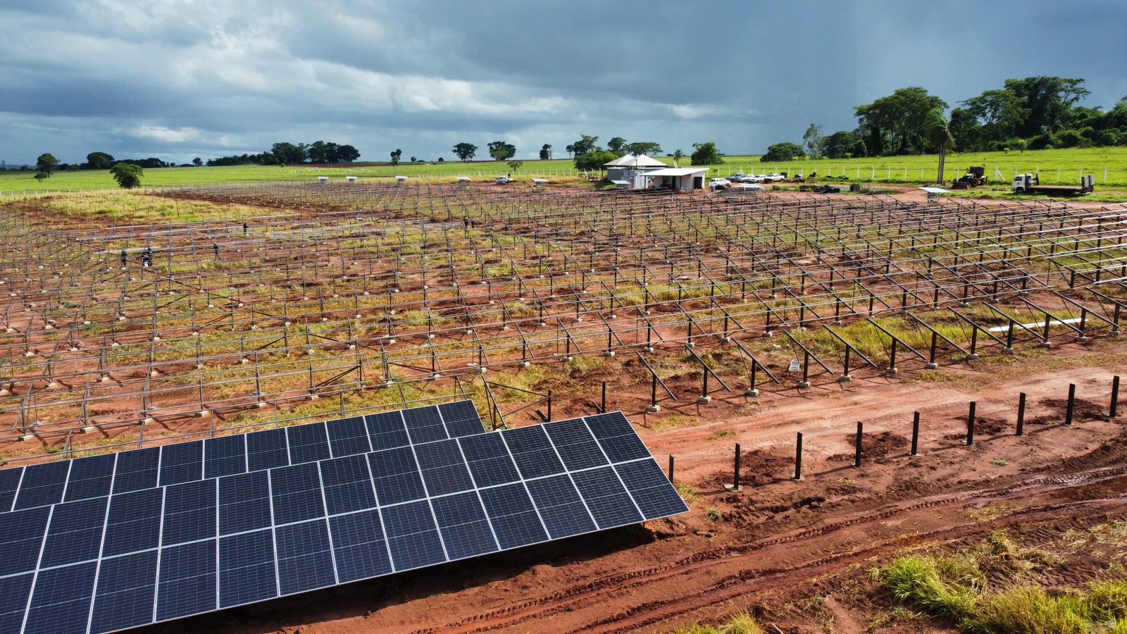 Painéis solares em fileiras sobre solo avermelhado