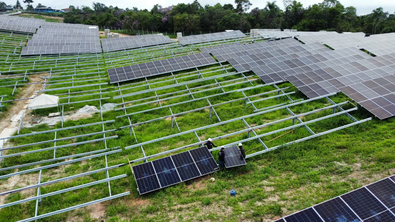 Painéis solares montados em estruturas metálicas sobre grama